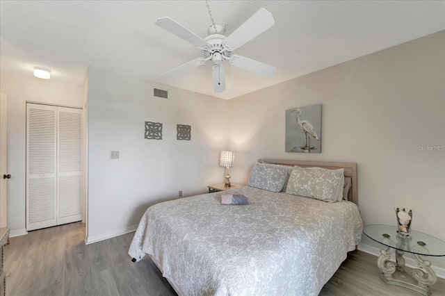 bedroom with hardwood / wood-style floors, ceiling fan, and a closet