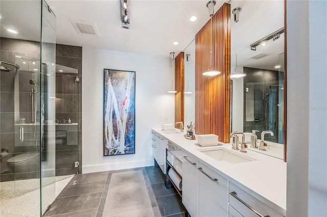 bathroom featuring tile patterned flooring, vanity, and a shower with shower door