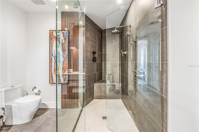 bathroom featuring tile patterned flooring, an enclosed shower, and toilet