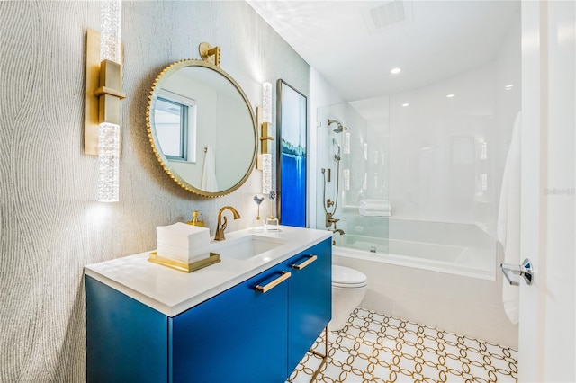 full bathroom featuring vanity, tiled shower / bath combo, and toilet