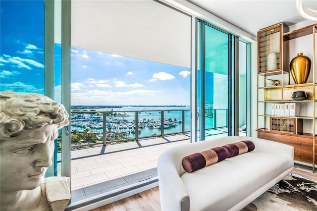 interior space featuring floor to ceiling windows, a water view, and light hardwood / wood-style floors