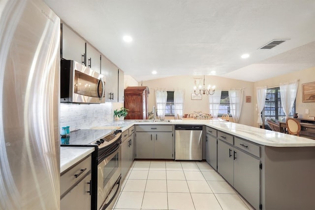 kitchen with lofted ceiling, sink, gray cabinets, kitchen peninsula, and stainless steel appliances