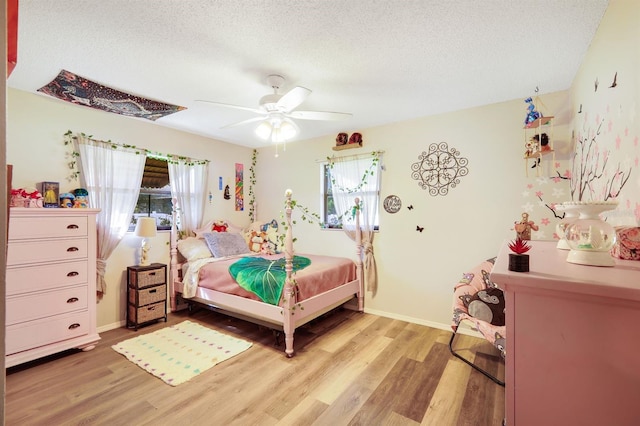 bedroom featuring wood-type flooring, a textured ceiling, and ceiling fan