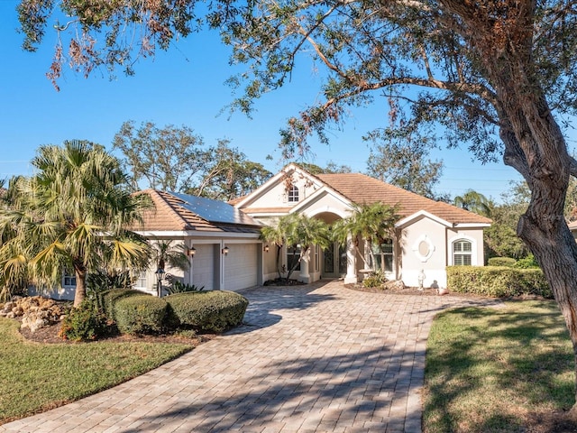 view of front of house featuring solar panels and a garage