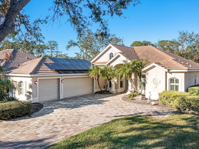 view of front of house with solar panels and a garage