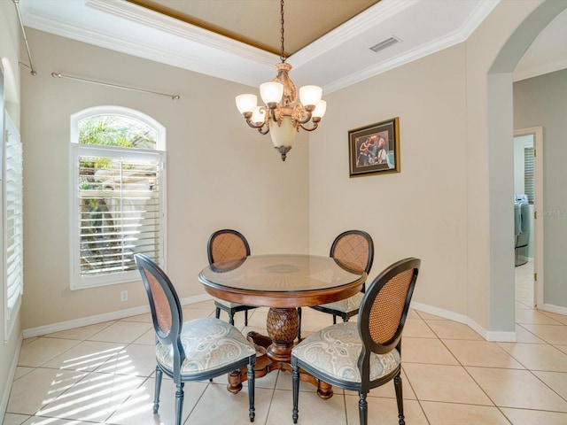 dining area with light tile patterned floors, washer / clothes dryer, an inviting chandelier, and ornamental molding