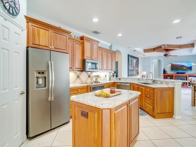 kitchen featuring sink, ceiling fan, appliances with stainless steel finishes, a kitchen island, and kitchen peninsula