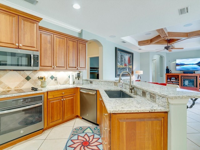 kitchen featuring ceiling fan, sink, kitchen peninsula, light tile patterned floors, and appliances with stainless steel finishes