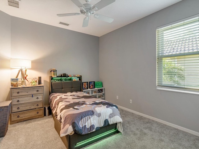 carpeted bedroom with multiple windows and ceiling fan