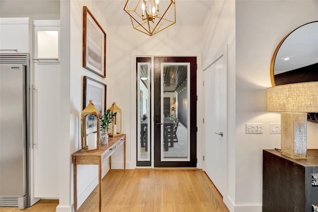 interior space featuring an inviting chandelier and light hardwood / wood-style flooring