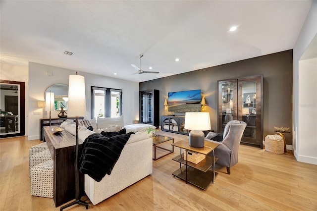 living room featuring ceiling fan and light hardwood / wood-style flooring