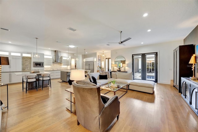 living room with light hardwood / wood-style flooring and ceiling fan