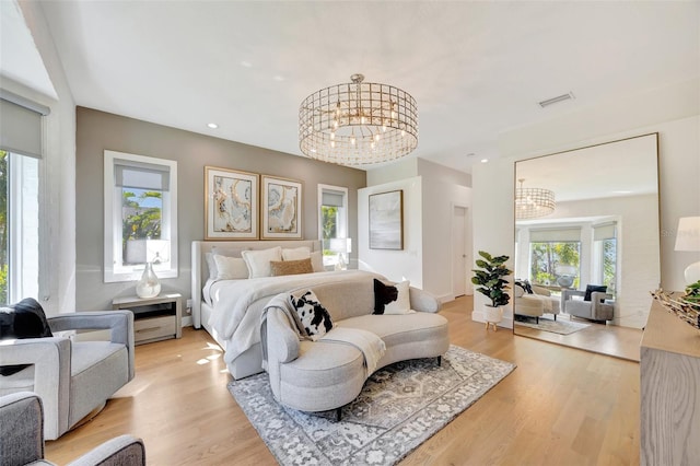 bedroom featuring multiple windows, hardwood / wood-style flooring, and a notable chandelier