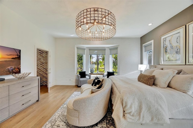 bedroom with light hardwood / wood-style flooring and an inviting chandelier