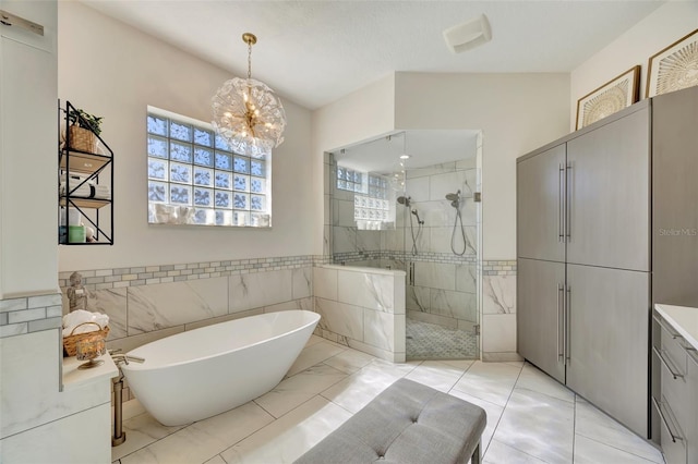 bathroom featuring vanity, independent shower and bath, tile walls, and a wealth of natural light