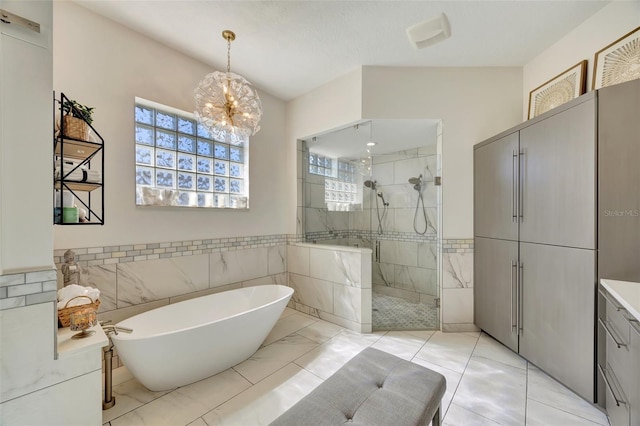 7003 River Club Blvd, Bradenton, FL 34202 - bathroom featuring tile walls, a freestanding bath, a tile shower, vanity, and a chandelier