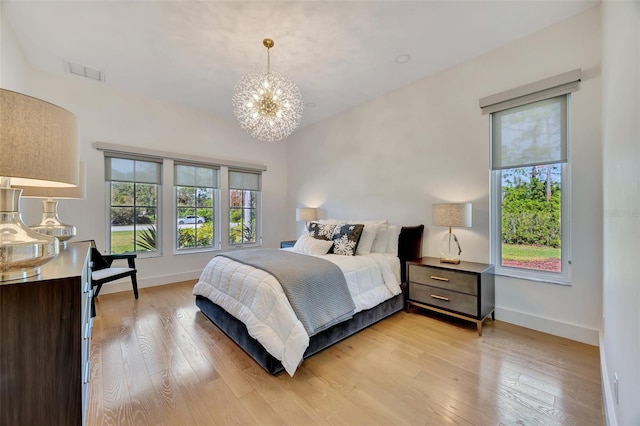 bedroom with a chandelier and light hardwood / wood-style flooring