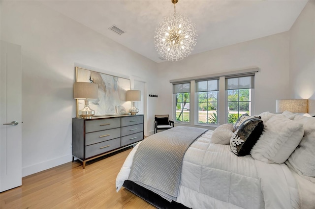 7003 River Club Blvd, Bradenton, FL 34202 - bedroom with a chandelier, vaulted ceiling, light wood-style floors, and baseboards