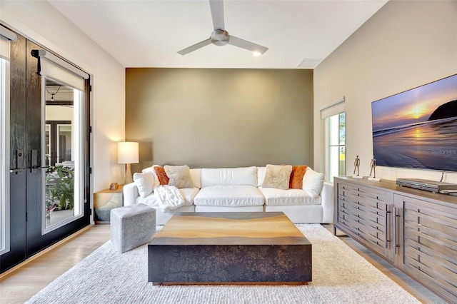 living room with light hardwood / wood-style flooring and ceiling fan