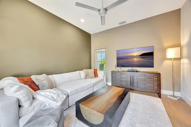 living room featuring light hardwood / wood-style floors, high vaulted ceiling, and ceiling fan