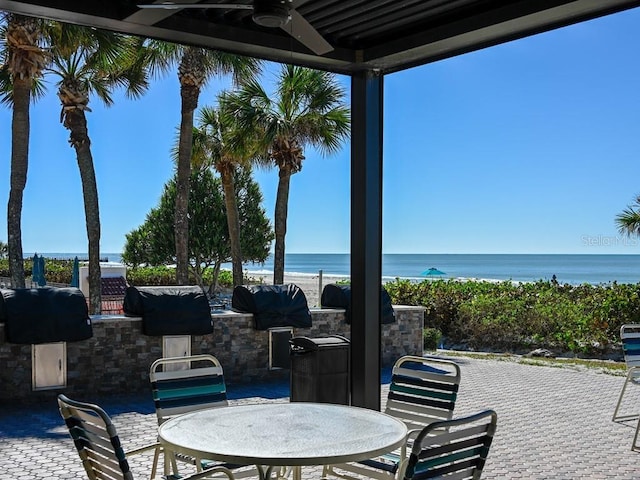 view of patio featuring ceiling fan, area for grilling, a water view, and grilling area