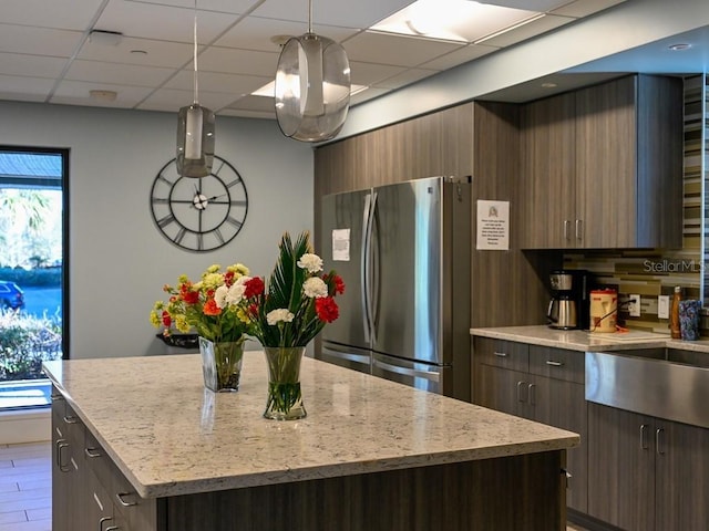 kitchen featuring a center island, decorative light fixtures, stainless steel fridge, and plenty of natural light