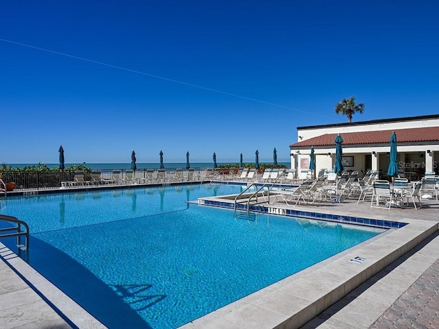 view of pool with a patio area and a water view