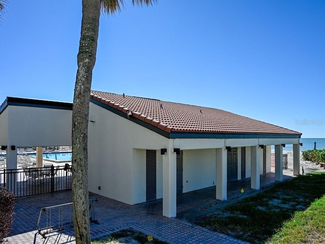 rear view of property featuring a patio area and a water view