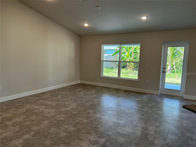 unfurnished room with a healthy amount of sunlight and vaulted ceiling