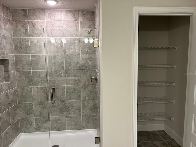 bathroom with tile patterned flooring and walk in shower