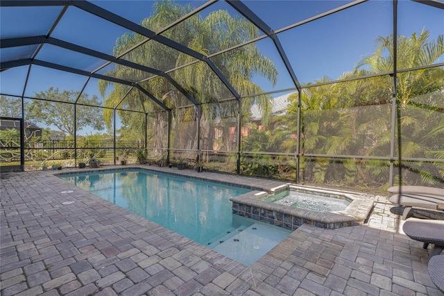 view of swimming pool with a patio area, a lanai, and an in ground hot tub