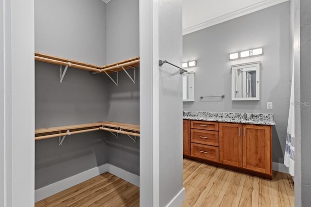 walk in closet featuring light hardwood / wood-style floors and sink