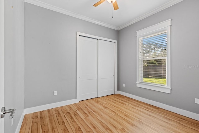 unfurnished bedroom with light wood-type flooring, a closet, ceiling fan, and ornamental molding