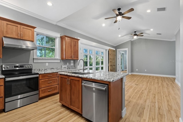 kitchen featuring a center island with sink, crown molding, sink, appliances with stainless steel finishes, and light hardwood / wood-style floors