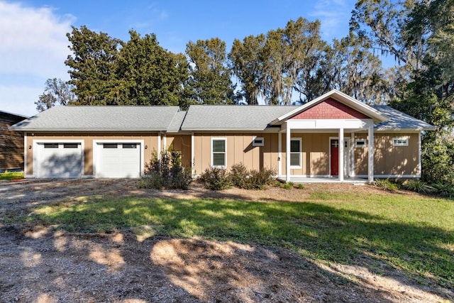 view of front of property with covered porch, a garage, and a front yard