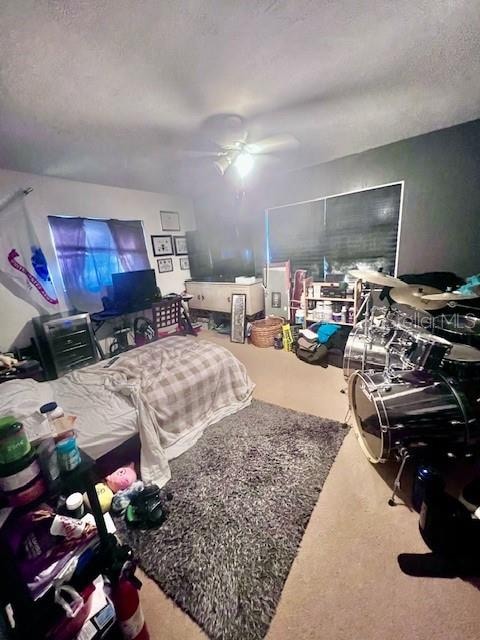 carpeted bedroom with ceiling fan and a textured ceiling