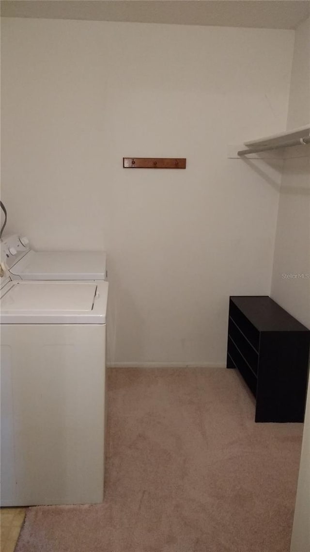 laundry area featuring washer / dryer and light carpet