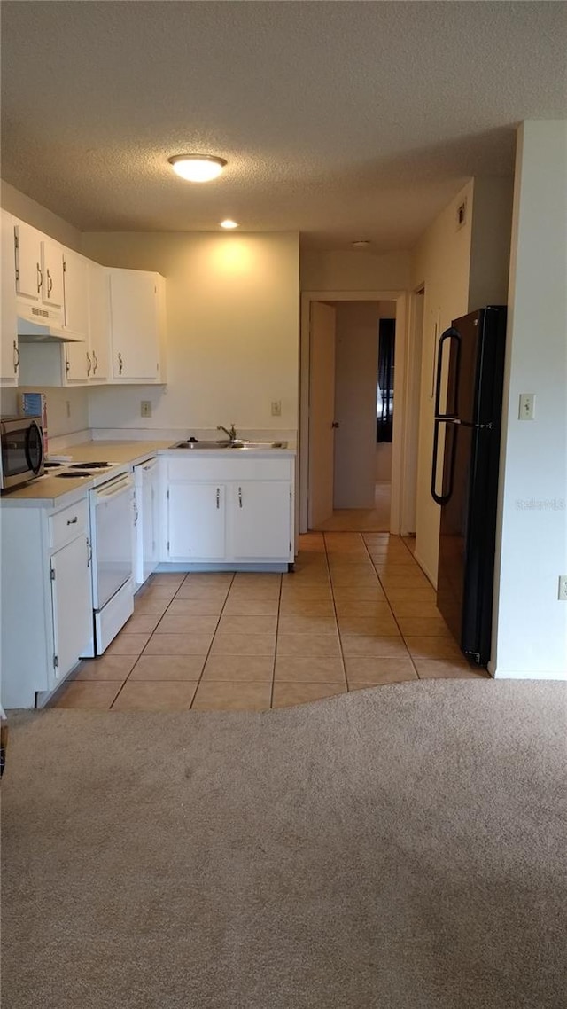 kitchen with white cabinetry, white electric range oven, black fridge, light colored carpet, and a textured ceiling