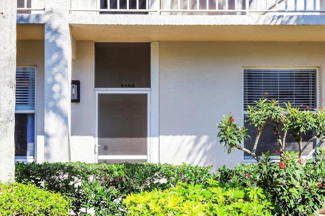 doorway to property featuring a balcony and stucco siding