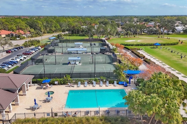 pool with a tennis court and fence