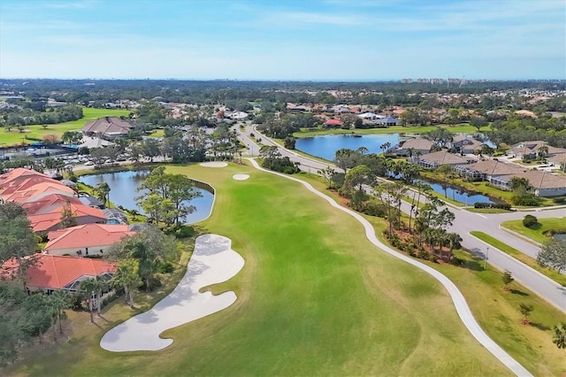 drone / aerial view featuring a water view, view of golf course, and a residential view