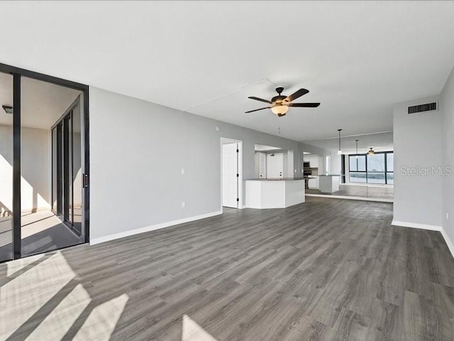 unfurnished living room featuring ceiling fan and dark hardwood / wood-style floors