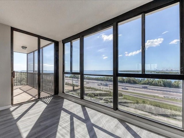 unfurnished sunroom with a water view