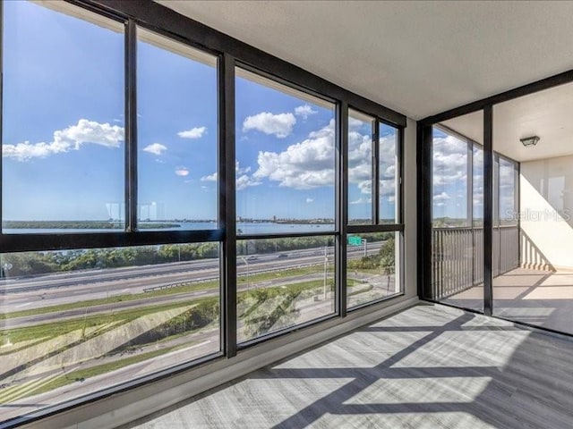 unfurnished sunroom with a healthy amount of sunlight and a water view