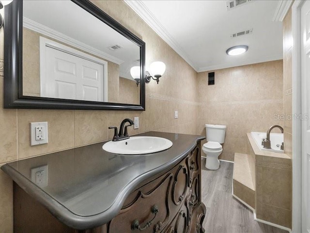 bathroom with ornamental molding, vanity, wood-type flooring, tile walls, and toilet