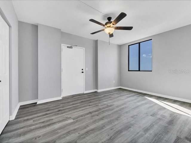 empty room with hardwood / wood-style floors and ceiling fan