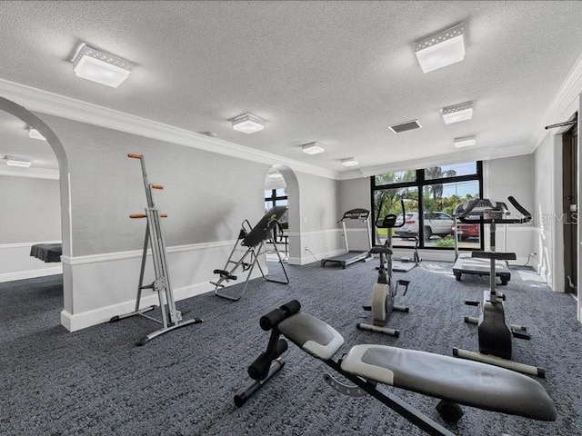 gym with dark colored carpet, a textured ceiling, and ornamental molding