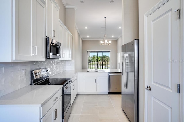 kitchen featuring white cabinets, stainless steel appliances, an inviting chandelier, and hanging light fixtures