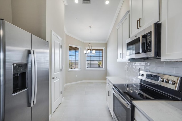 kitchen featuring white cabinetry, a notable chandelier, pendant lighting, appliances with stainless steel finishes, and ornamental molding