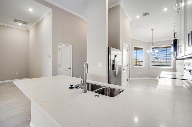 kitchen with sink, crown molding, stainless steel fridge, pendant lighting, and white cabinets